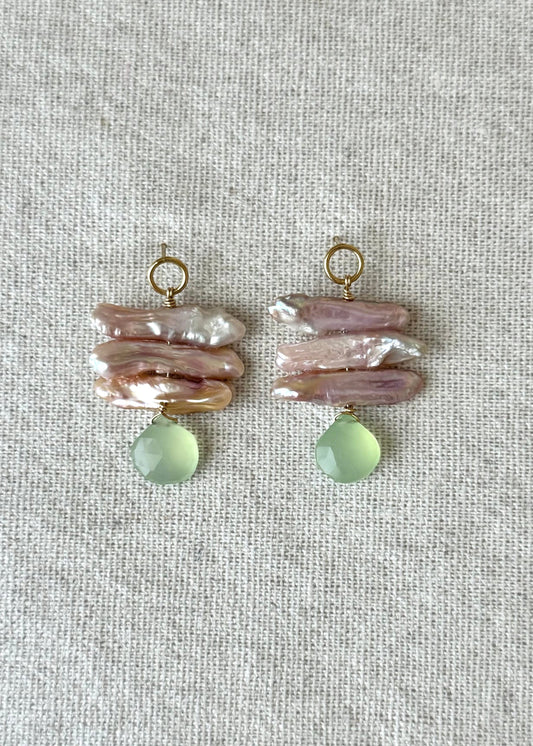 Pair of earrings with pink and green stones on a light gray background