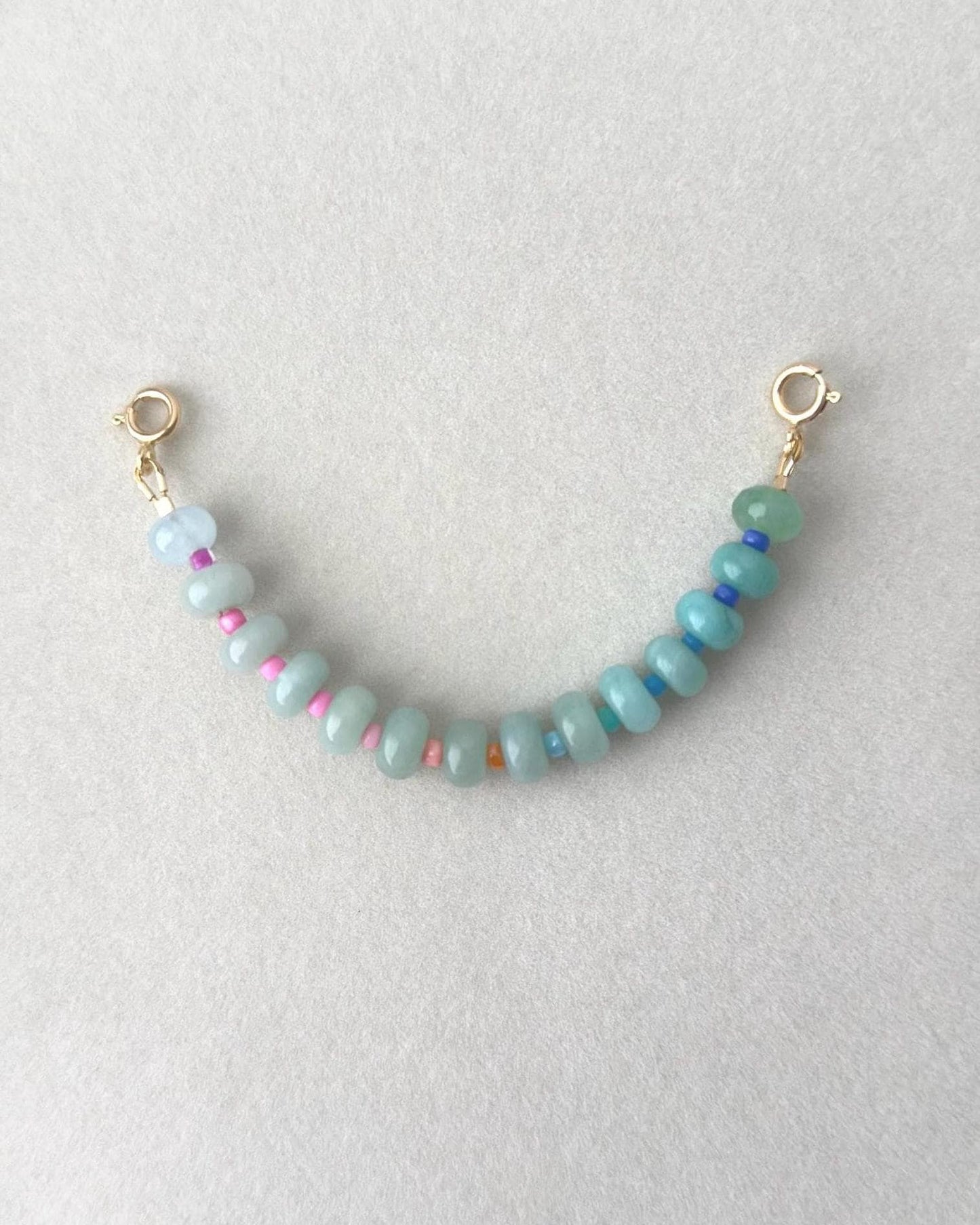 Ombré effect  beaded gemstone bracelet with gold clasps on a light gray background