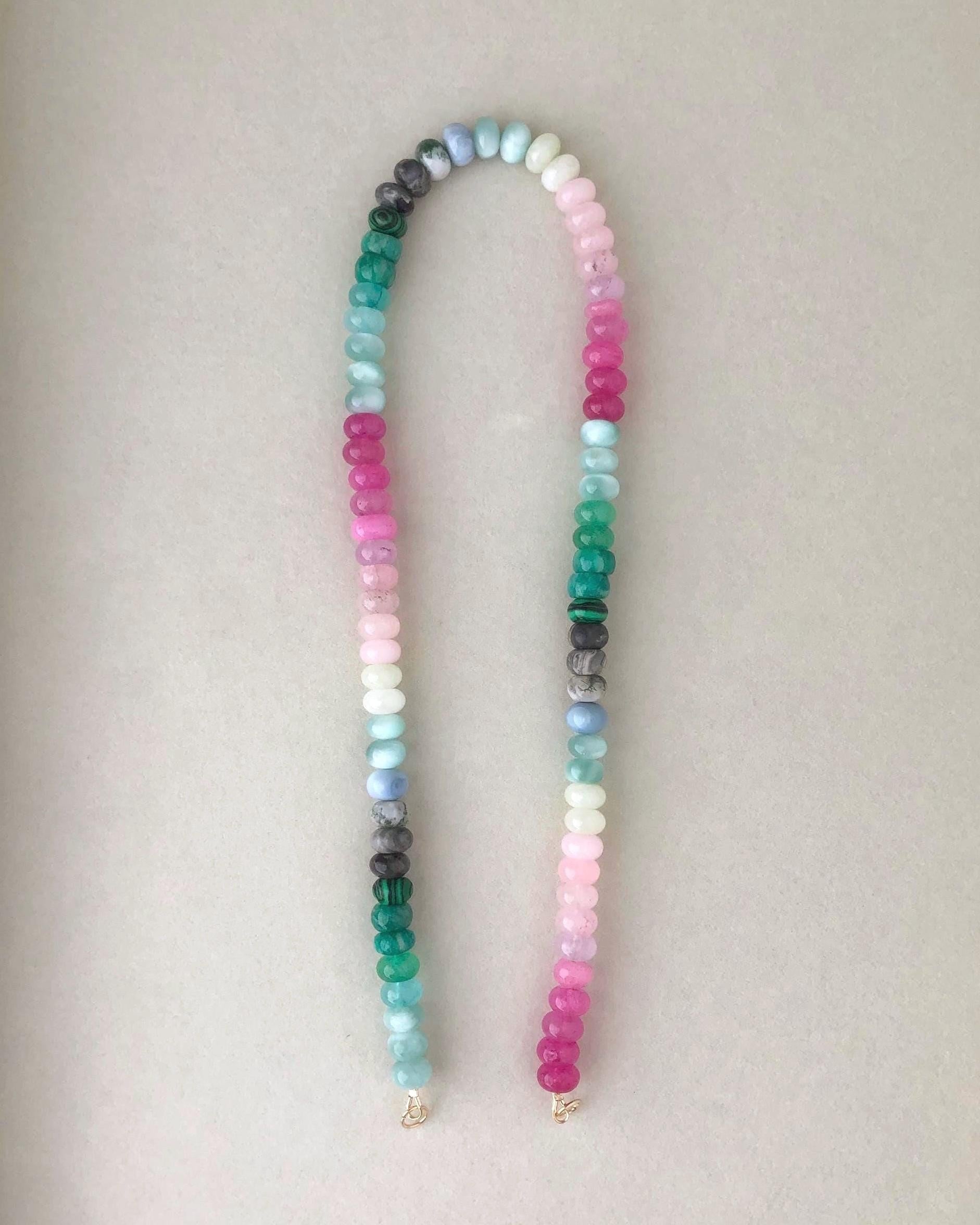 Bright multicolored gemstone bead necklace on a light beige background