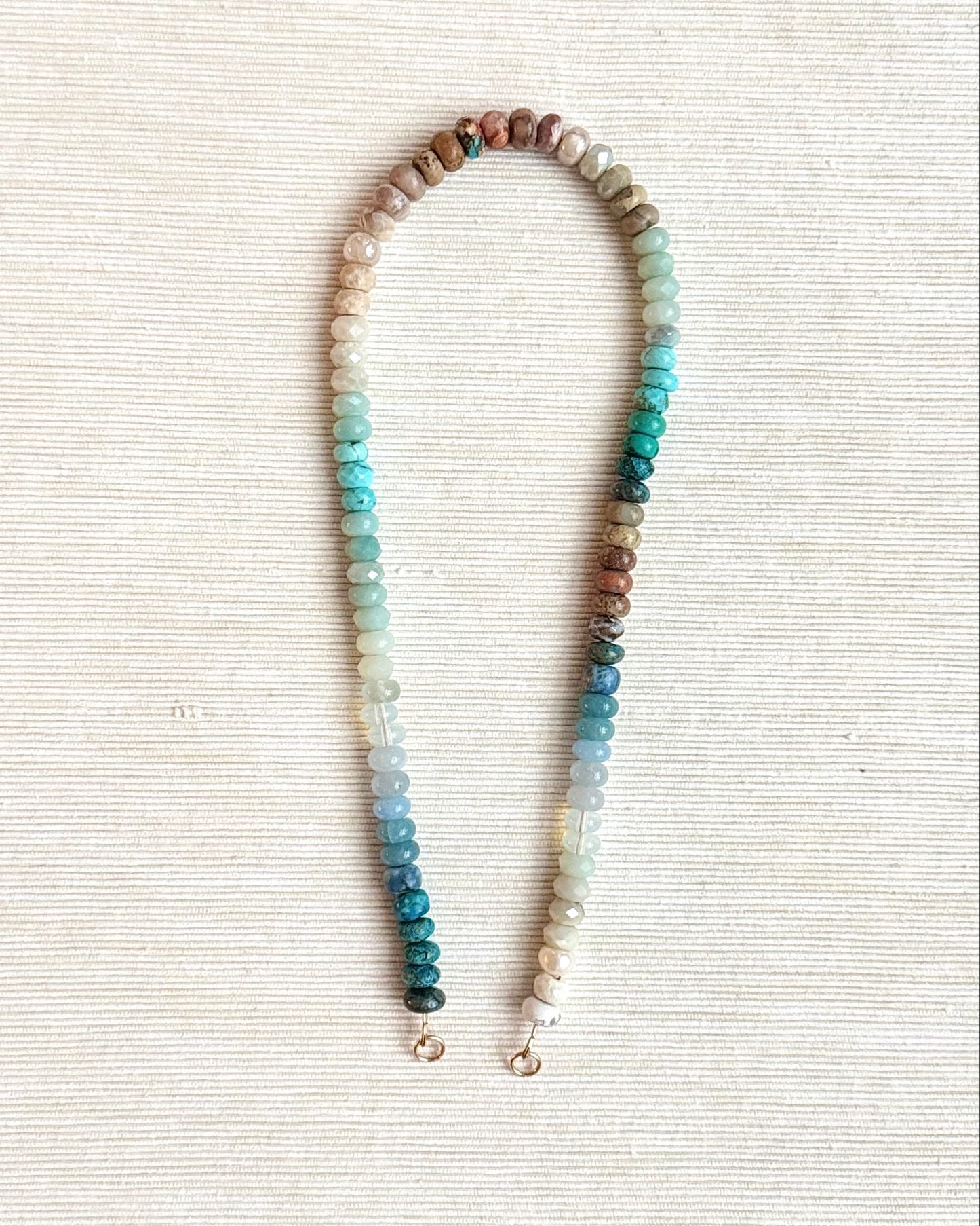 Necklace with multicolored beads on a light fabric background