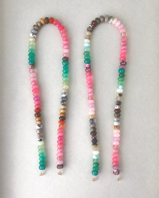 Two beaded gemstone necklaces with colorful mixed ombre effect gemstones on a light gray background
