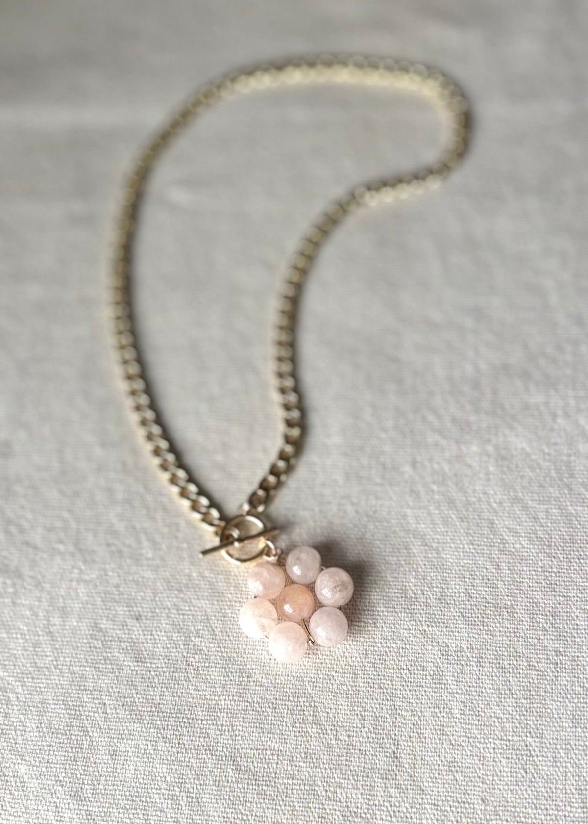 Necklace with a floral pendant on a light beige background