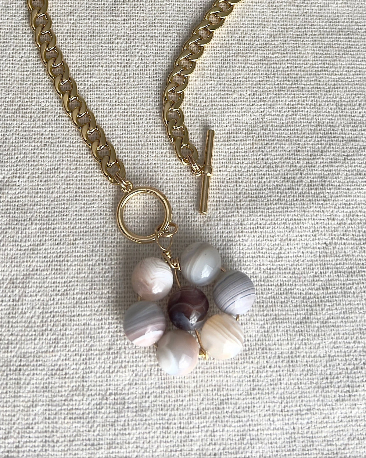 Necklace with floral pendant on a textured surface