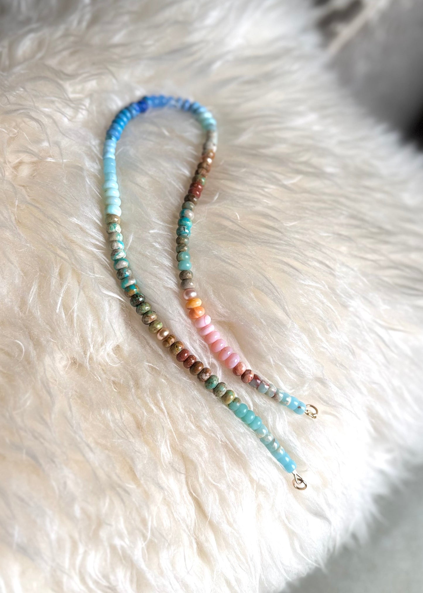 Multicolored beaded necklace on a fluffy white surface