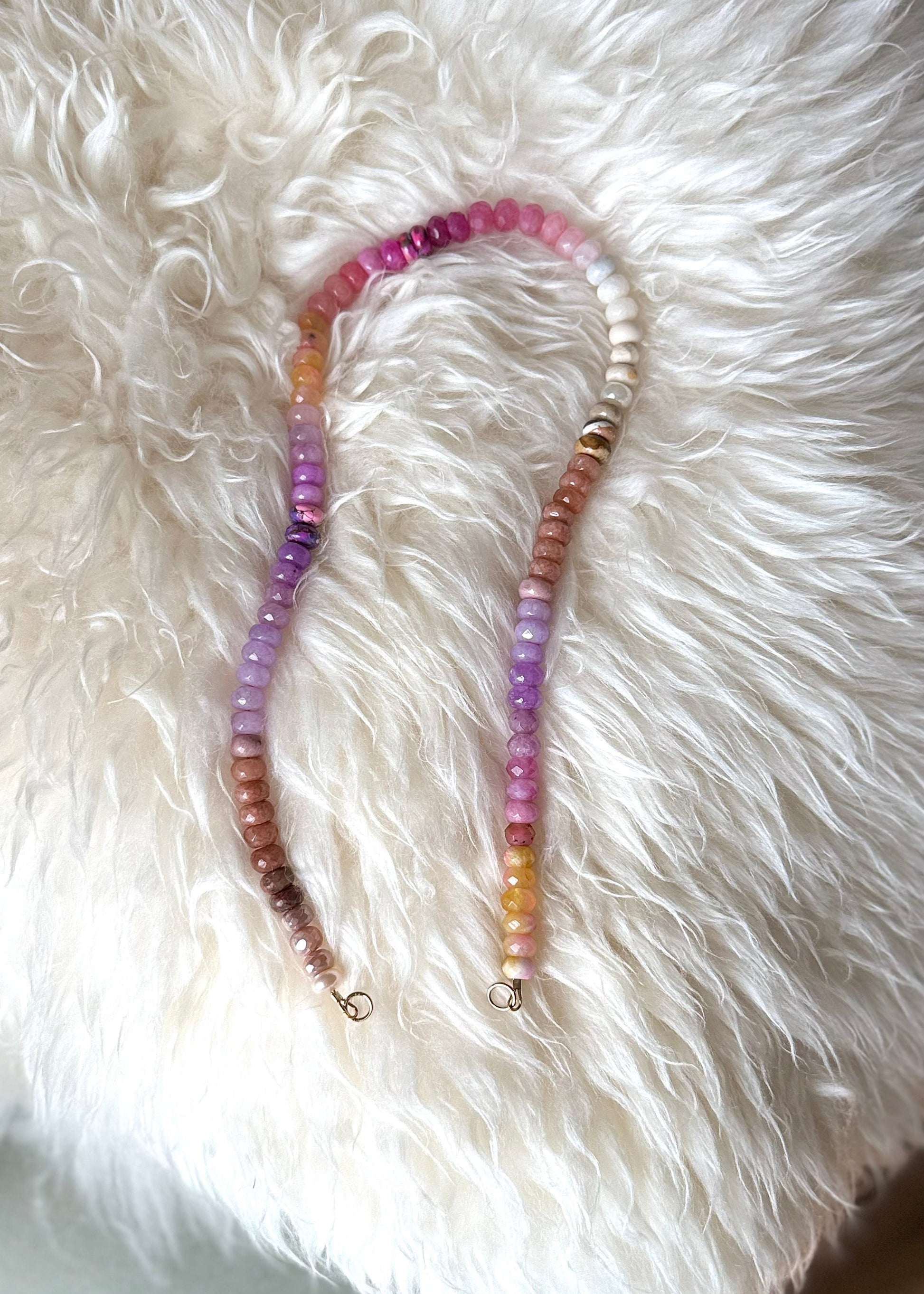 Necklace with multicolored beads on a white fur surface