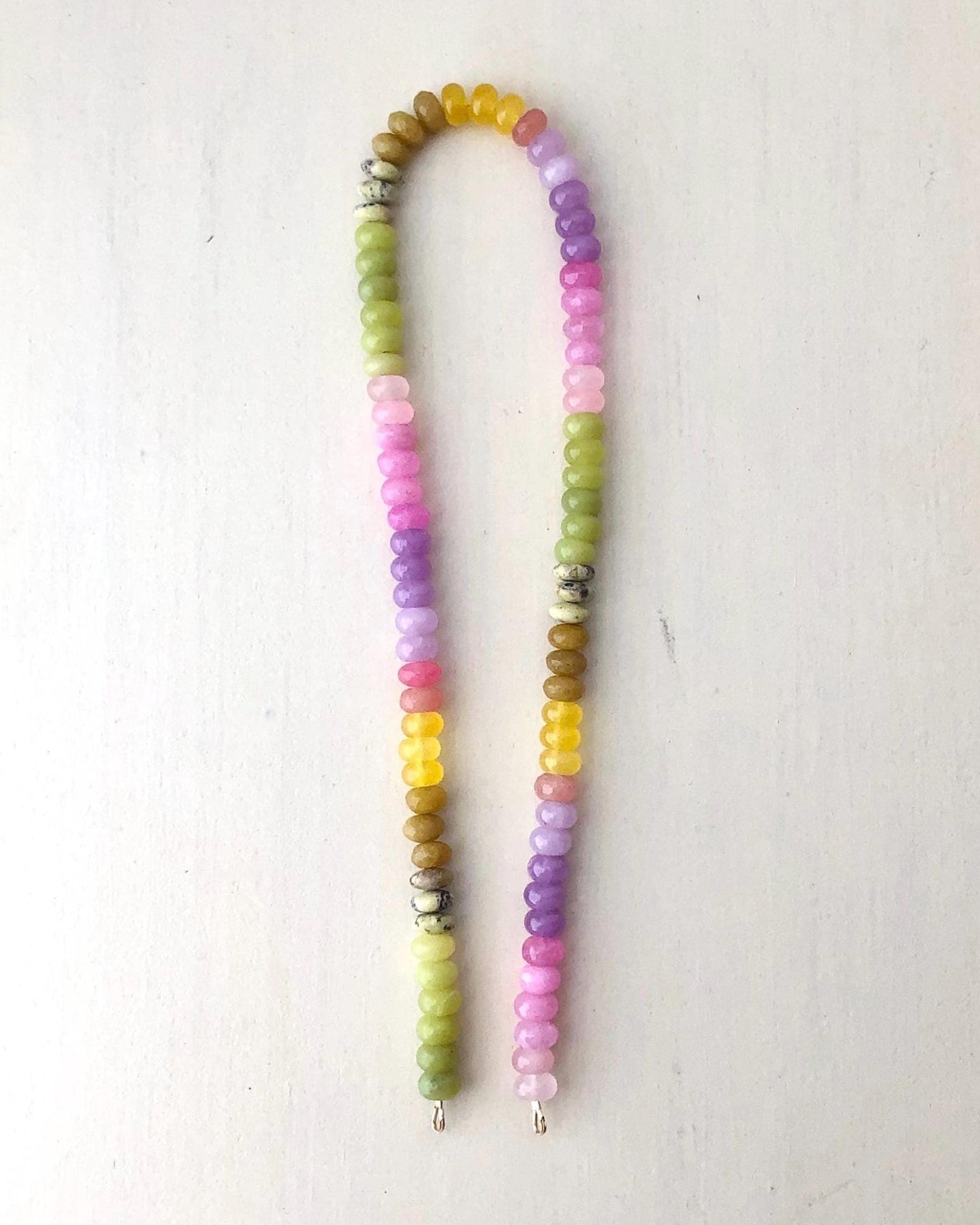 Colorful ombré effect gemstone beaded necklace on a cream background