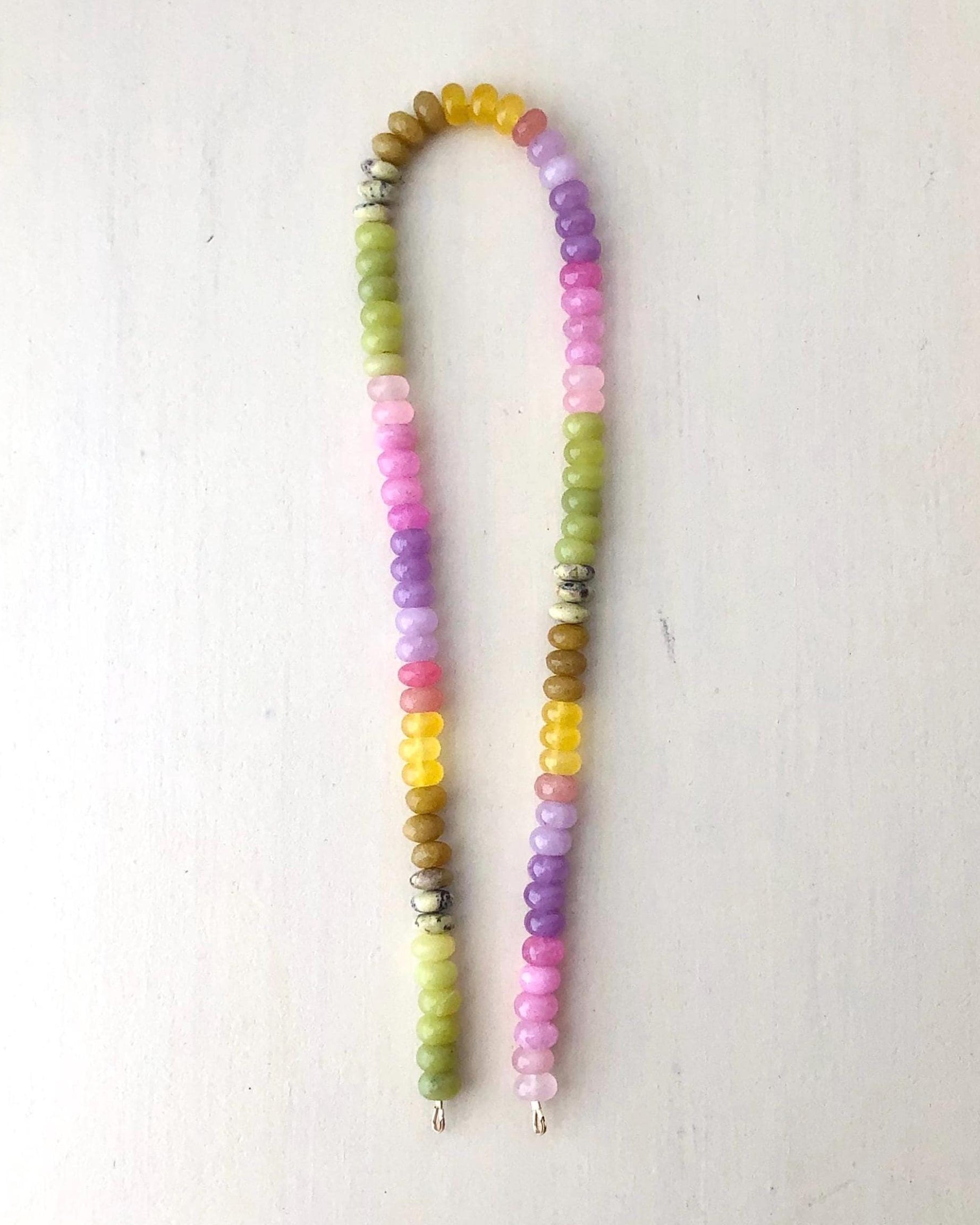 Colorful ombré effect gemstone beaded necklace on a cream background