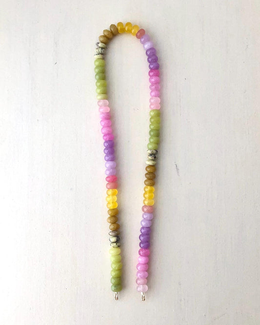 Colorful ombré effect gemstone beaded necklace on a cream background