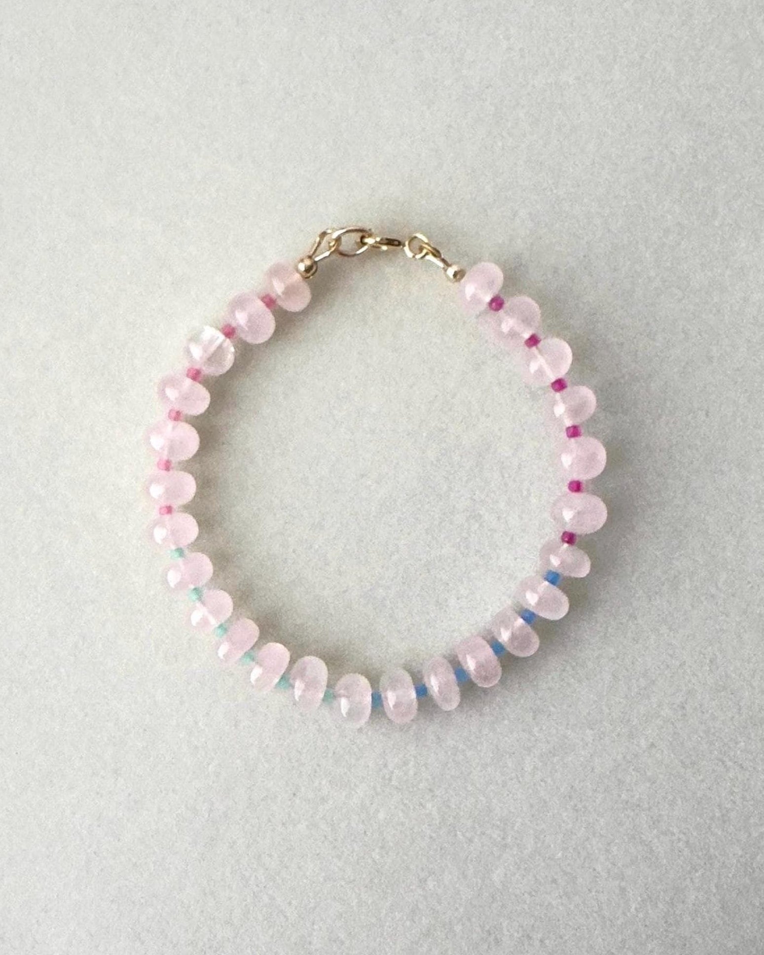 Gemstone Beaded bracelet with pink and multicolor gems with seed beads on a light gray background