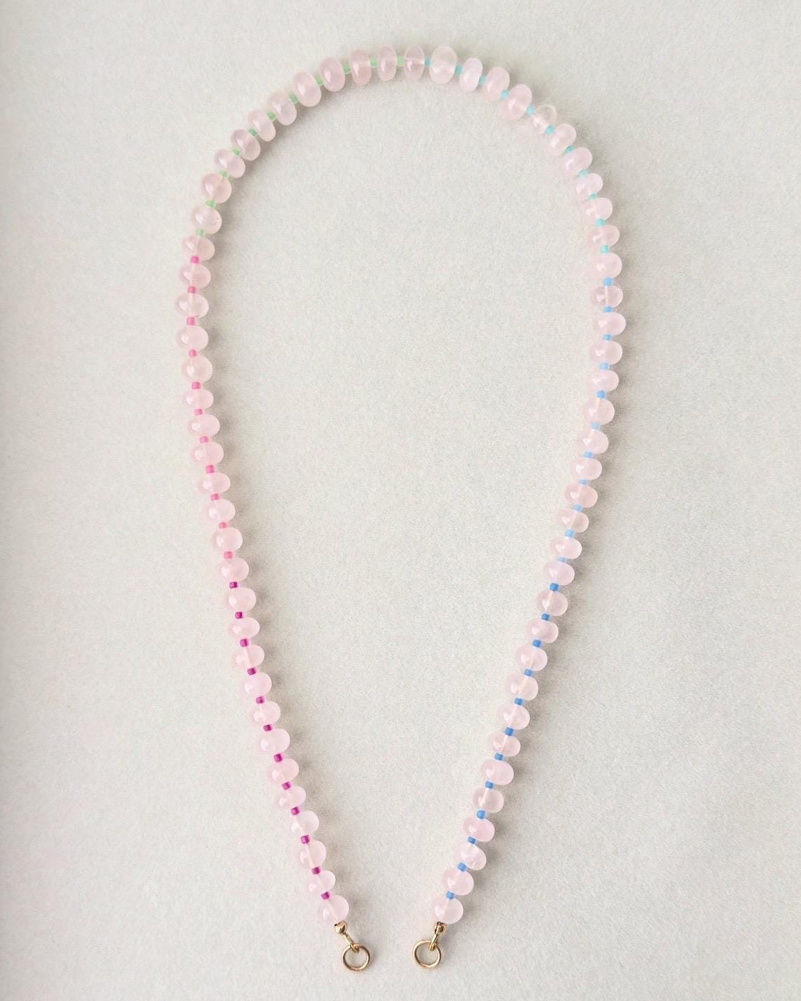 Necklace with pink and white beads on a light gray background