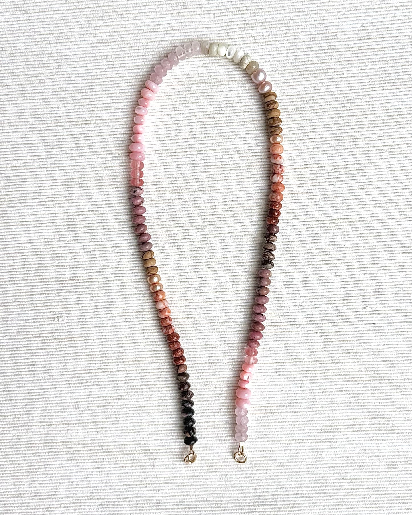 Necklace with multicolored beads on a textured white surface