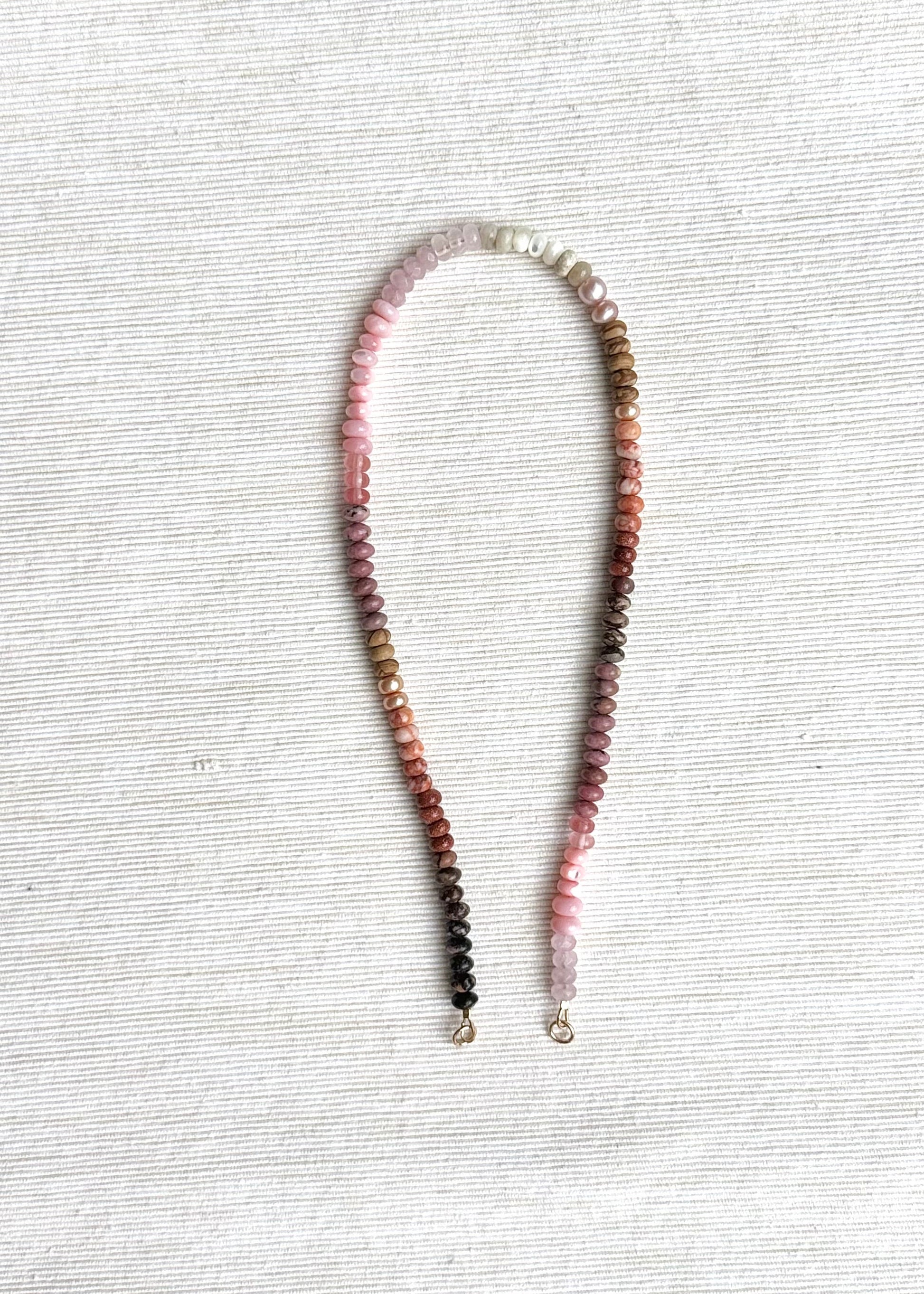 Necklace with multicolored beads on a textured white surface