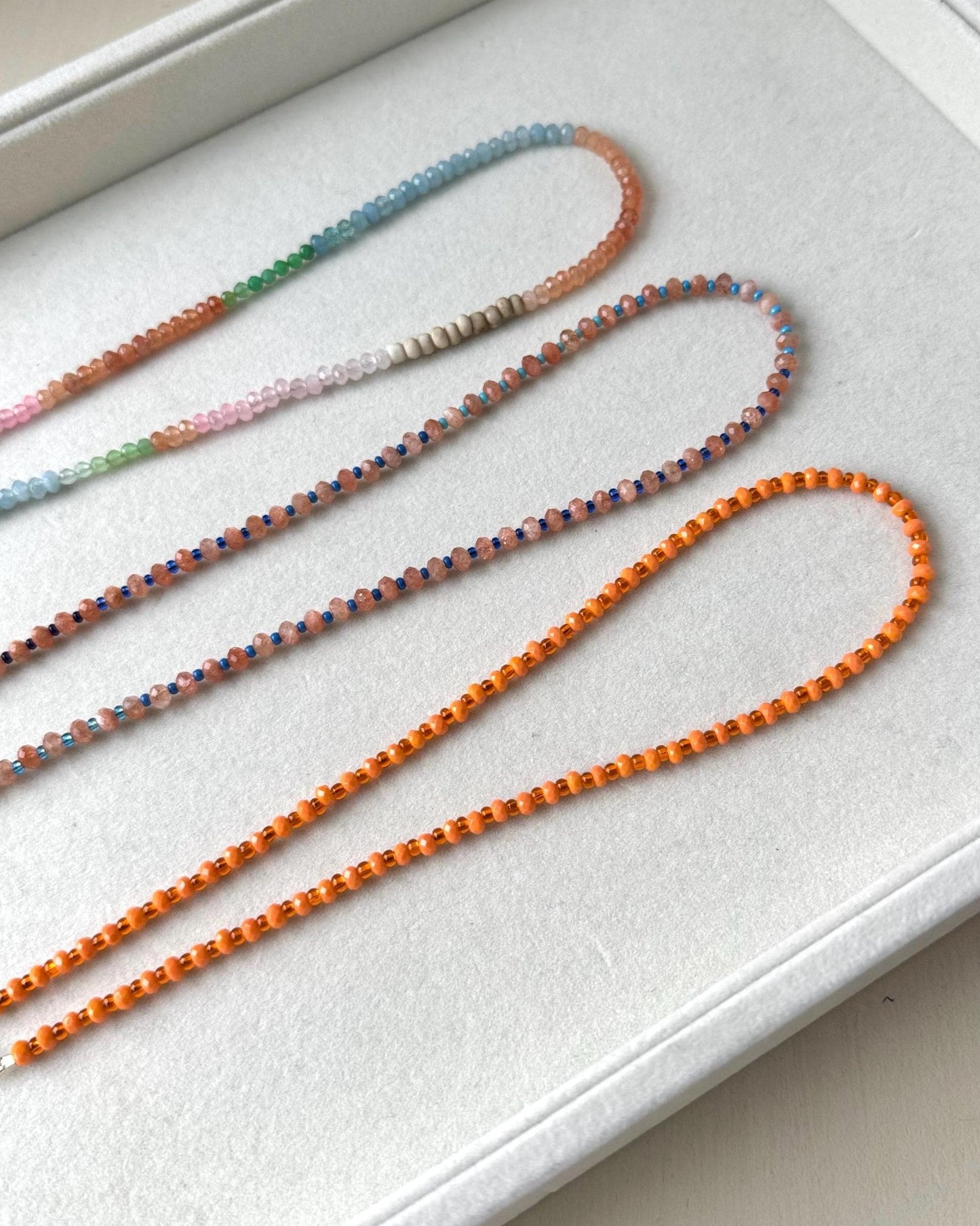 Set of colorful beaded lanyards on a white surface