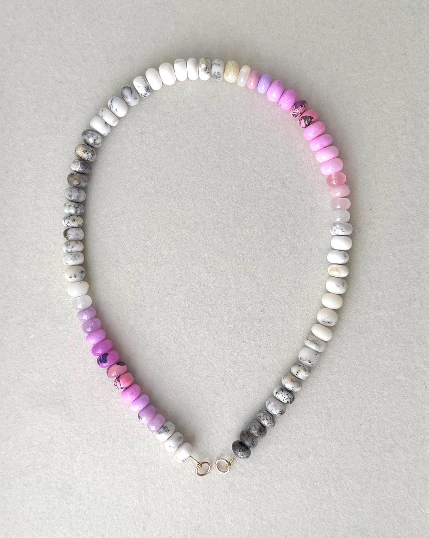 Beaded opal gemstone necklace with multicolored ombre effect beads in a gray frame
