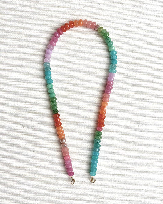 Multicolored beaded necklace on a white textured background