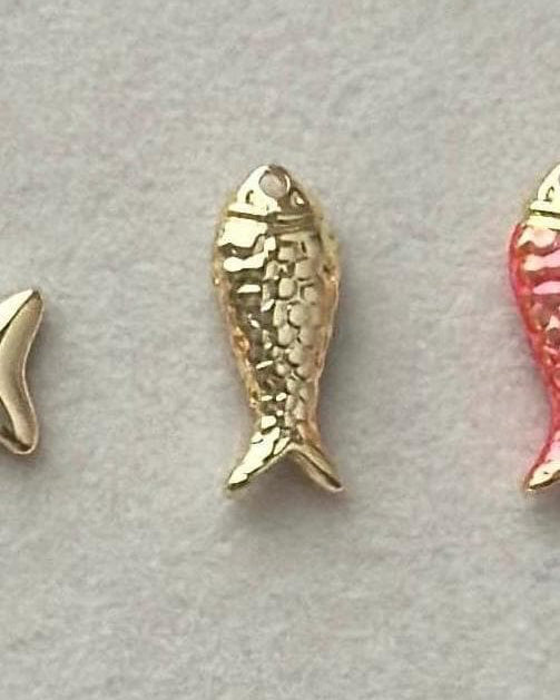 Gold fish-shaped charms on a gray background